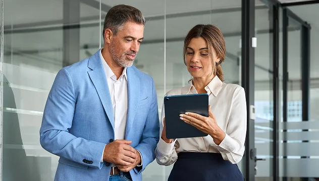 Business professionals reviewing investment portfolio on tablet – Synergos Capital AG Real Estate Secondary Portfolio Zurich Frankfurt